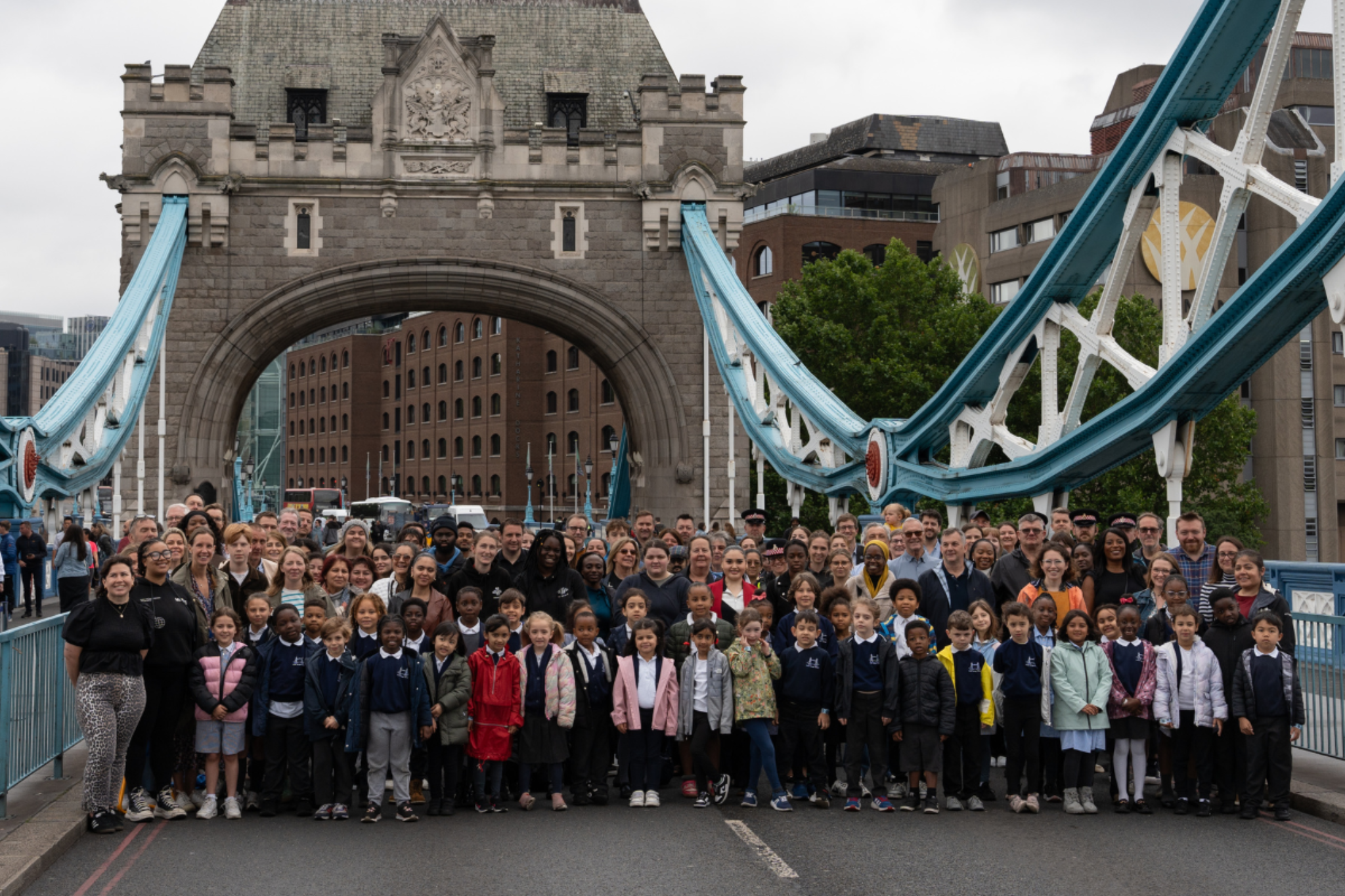 A large crowd of people on today's Tower Bridge, recreating the old photograph