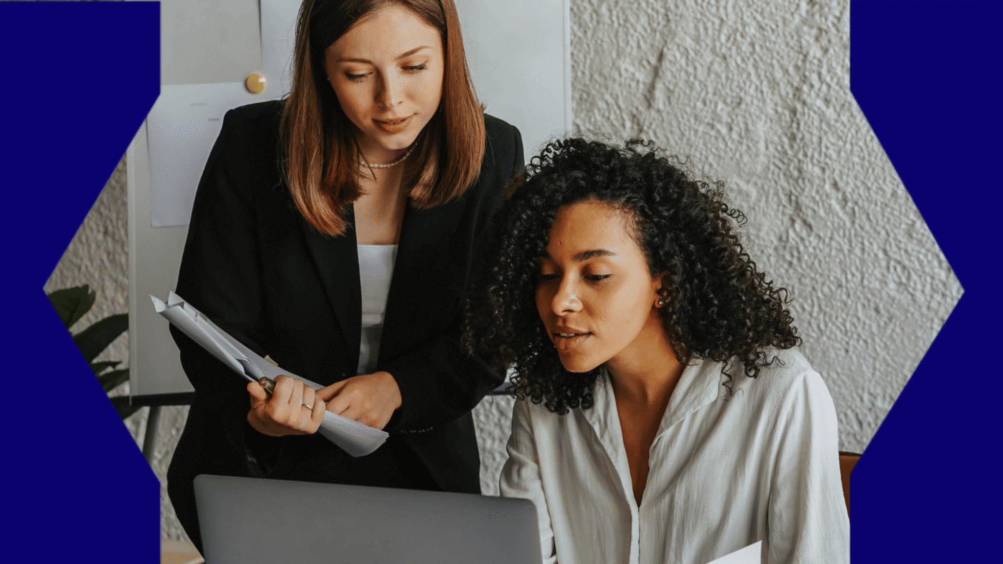 Two women looking at a laptop computer.